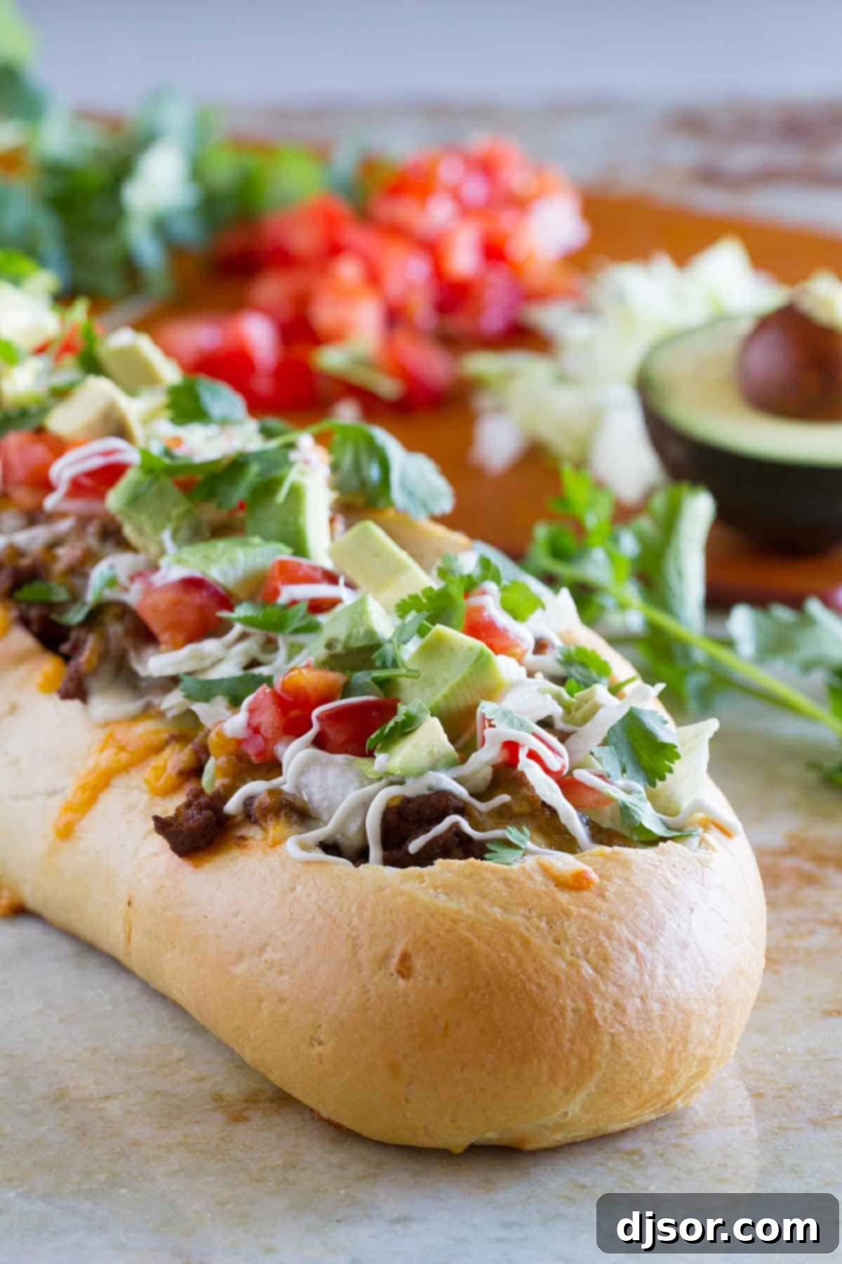 Crispy Taco Pizza Boats 4 An enticing close-up of a French bread loaf, carved into a 'boat' and generously filled with seasoned taco meat and shredded cheese before baking.