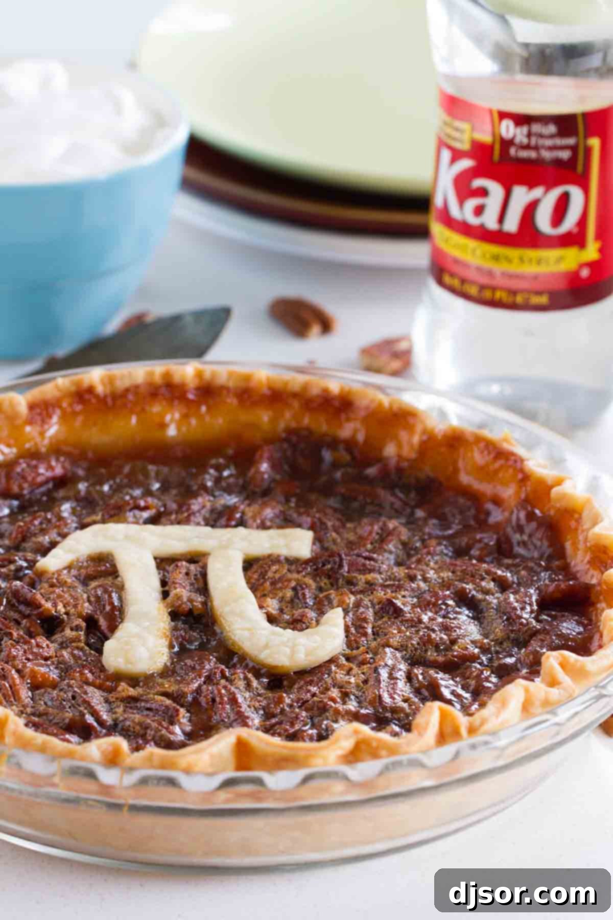A beautifully baked Classic Pecan Pie featuring a decorative 'Pi' symbol made from pie dough on top, showcasing a golden crust.