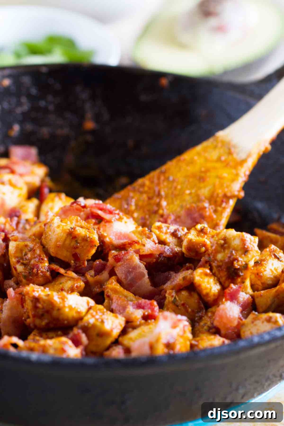 Stacked Chicken Bacon Avocado Tacos 4 Close-up of the delicious filling for Chicken Bacon Avocado Tacos being prepared in a skillet, showcasing the seasoned chicken and crispy bacon pieces.