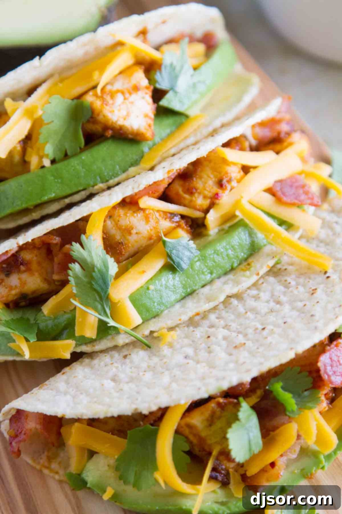 Stacked Chicken Bacon Avocado Tacos 7 A close-up view of a selection of crunchy hard-shell Chicken Bacon Avocado Tacos, showcasing the rich filling and fresh toppings.