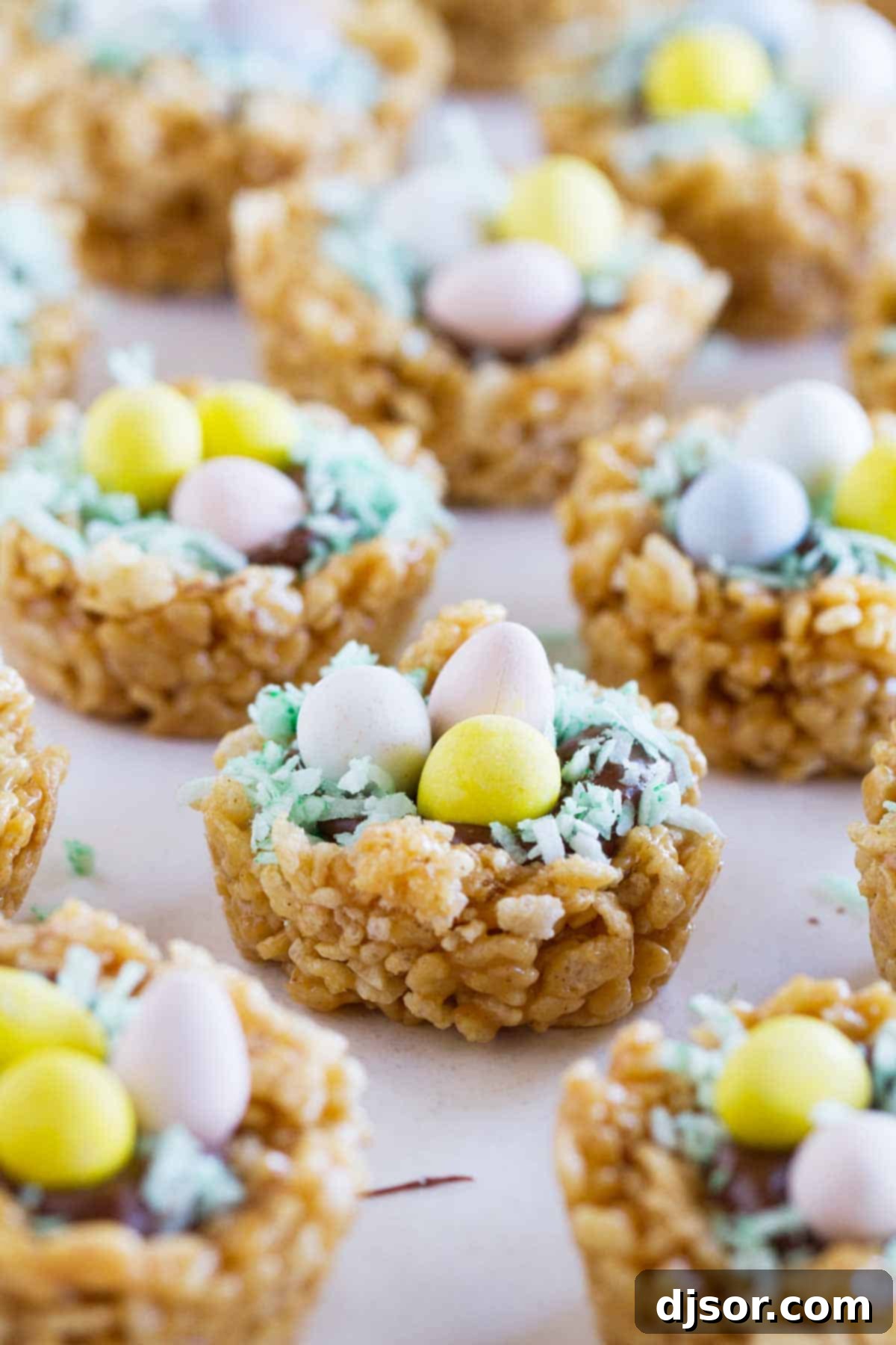 Adorable Easter Basket Scotcheroos featuring a crisp, peanut butter-infused base, topped with smooth chocolate and butterscotch, garnished with green coconut 'grass' and colorful chocolate eggs.