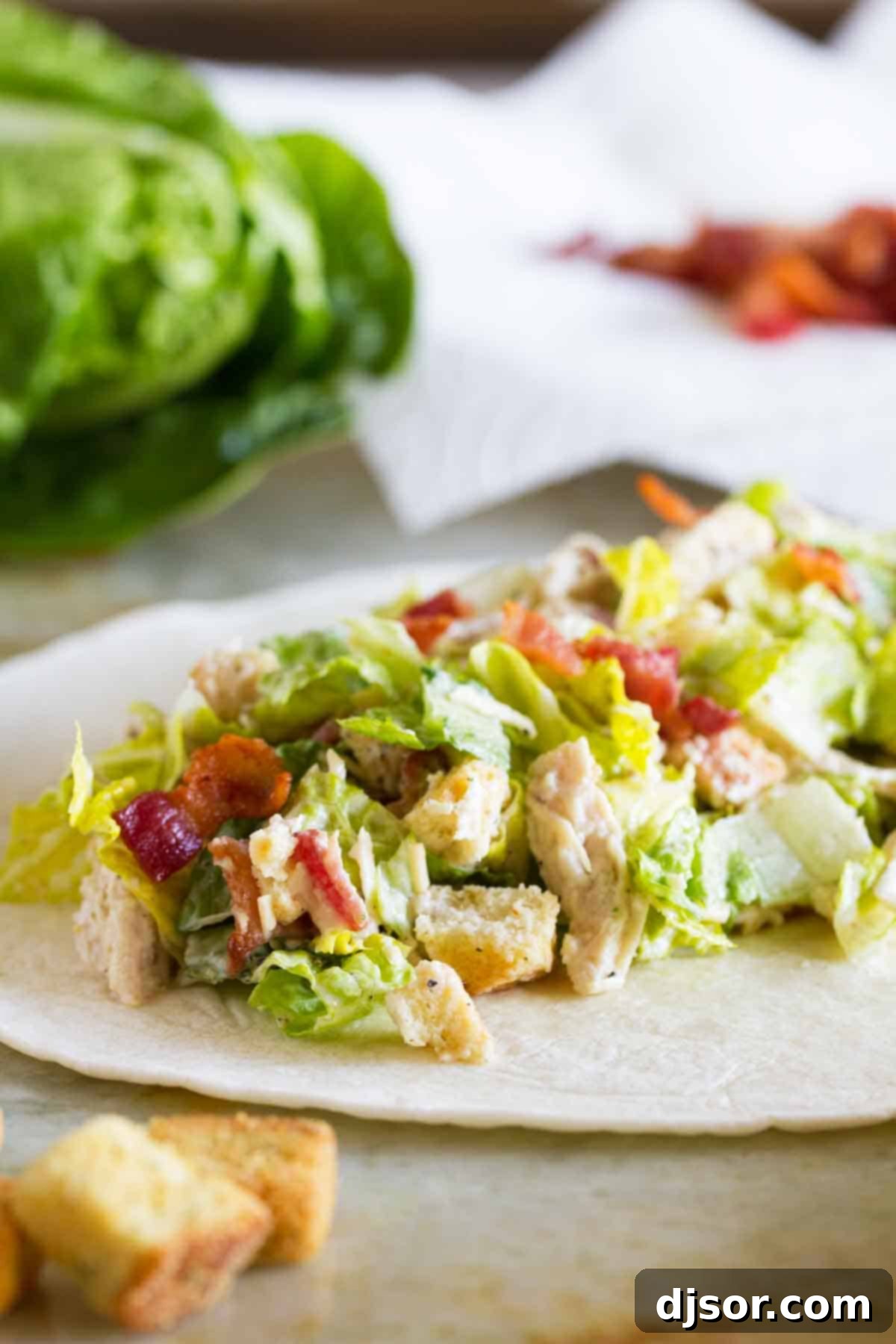 Regal Chicken Caesar Wraps 4 A tortilla generously filled with Chicken Caesar Salad ingredients, ready to be rolled.