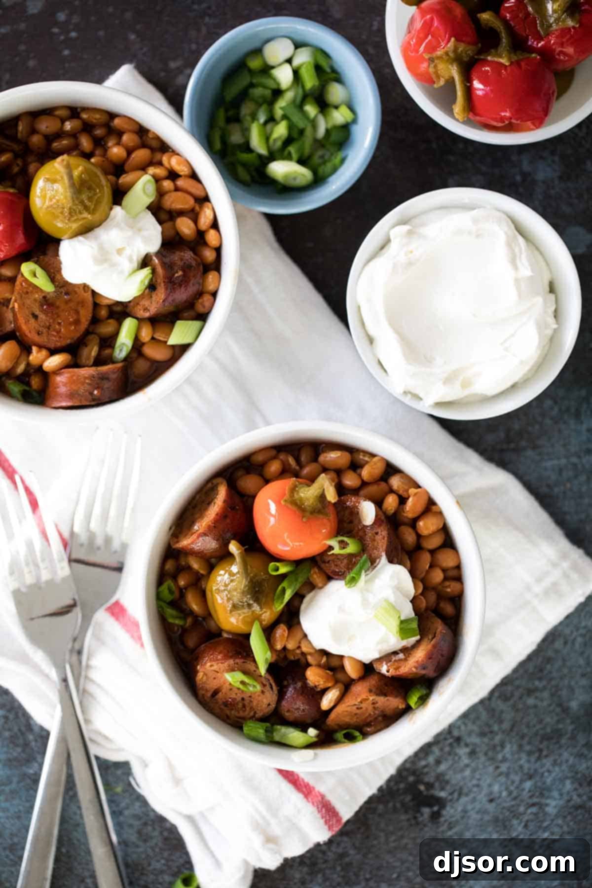 Slow Cooker Barbecue Beans and Sausage: A Hearty, Frugal Family Favorite Crock Pot Beans and Sausage in bowls, topped with cherry peppers and onions.
