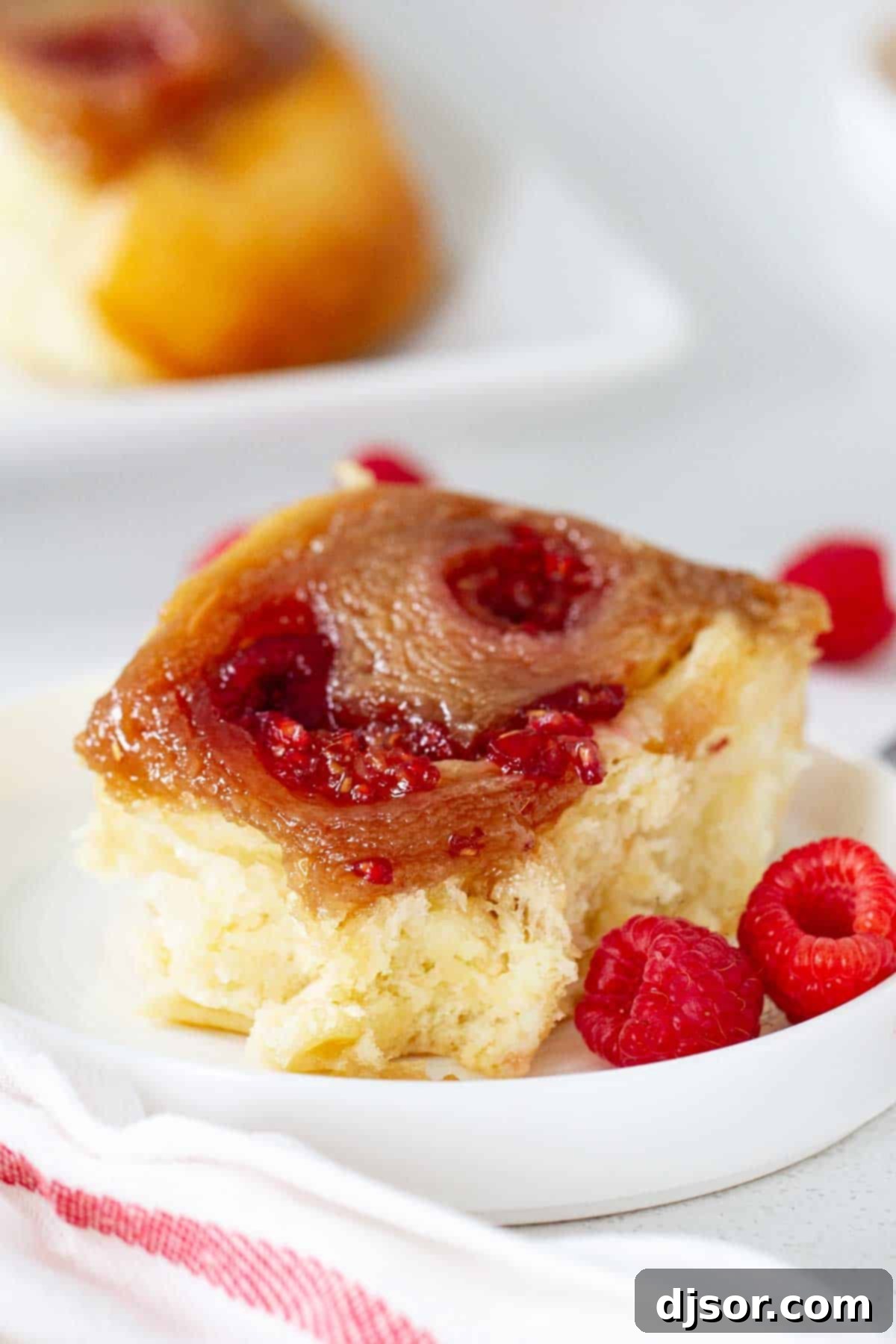 Delightful Raspberry Caramel Sticky Bun with fresh raspberries on top, ready to be enjoyed.
