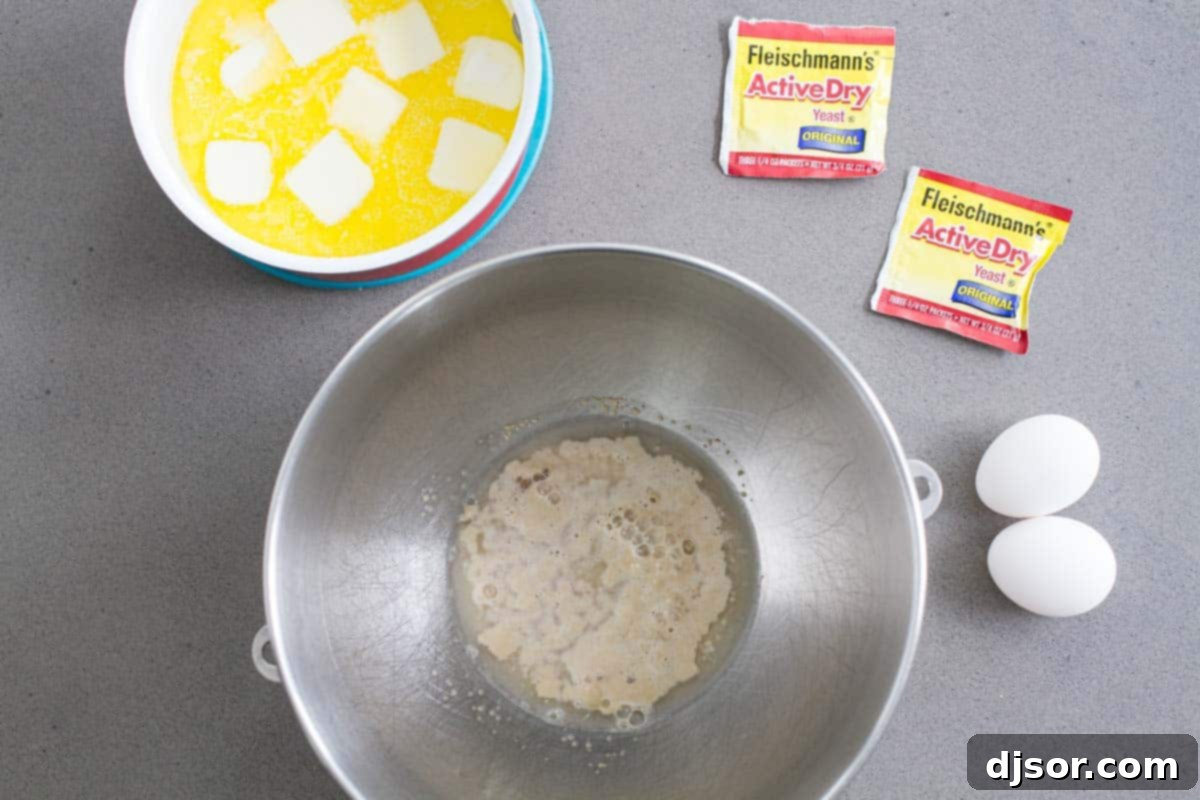 A collection of fresh ingredients laid out for making Raspberry Caramel Sticky Buns, including flour, sugar, butter, eggs, and vibrant raspberries.