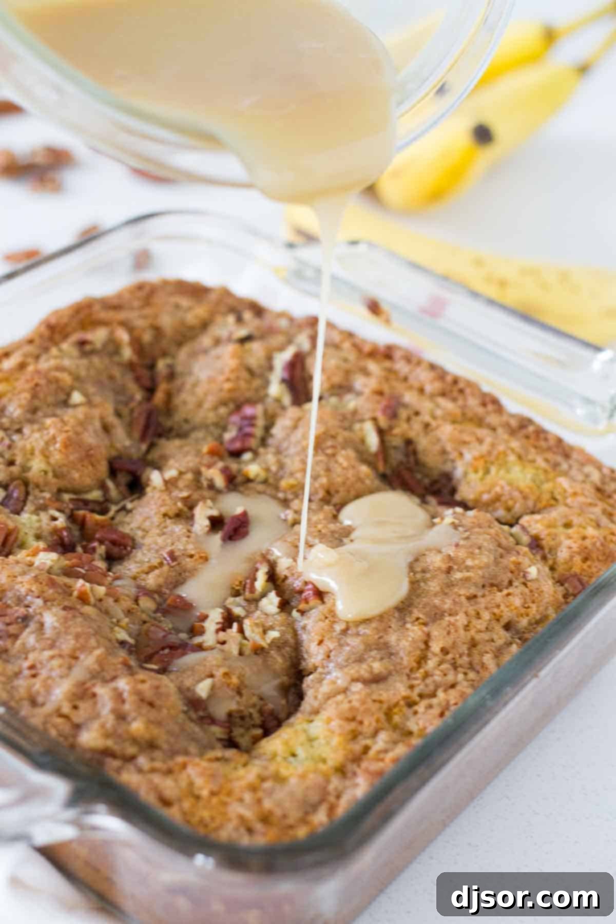 pouring glaze over banana coffee cake
