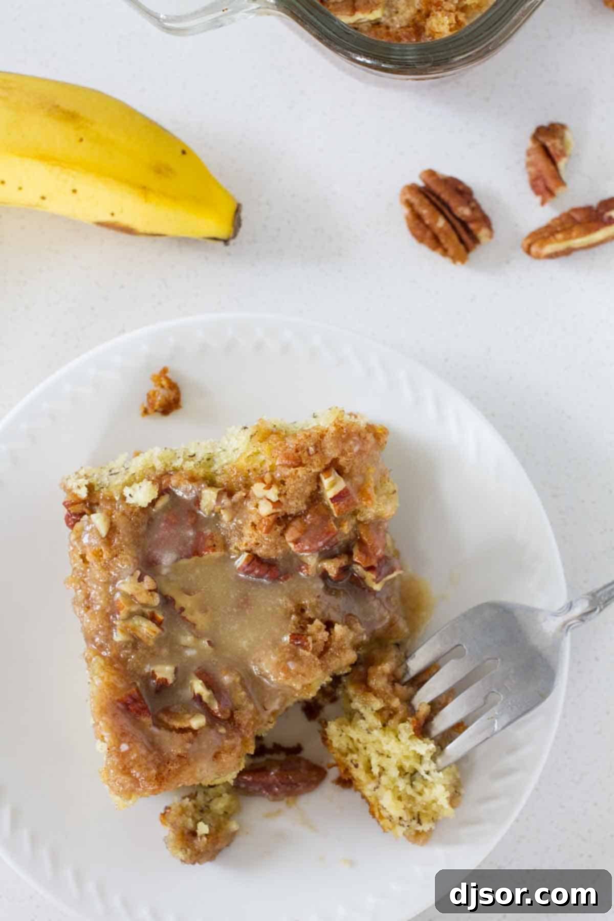 slice of banana coffee cake with a fork taking a bite