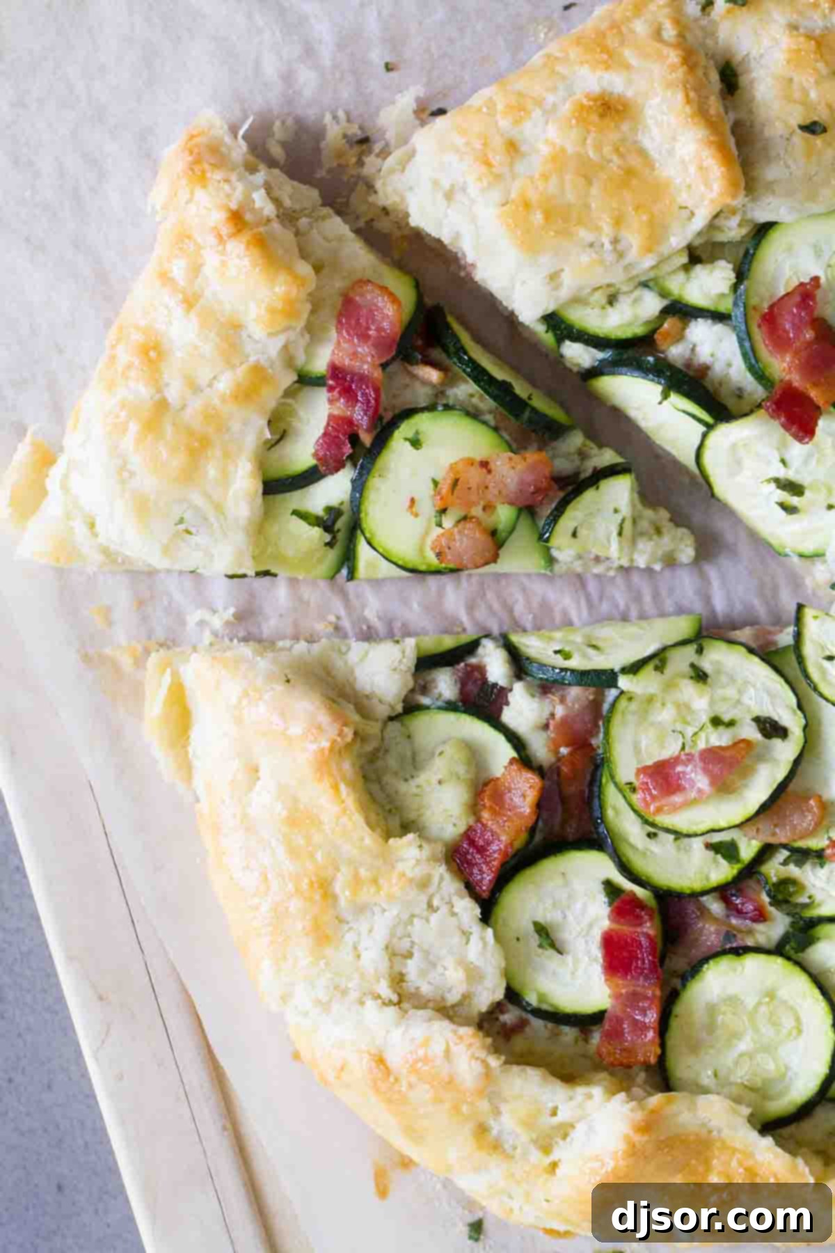A tender, flaky crust is filled with a creamy ricotta filling, then topped with bacon and zucchini in this easy Zucchini Tart with Ricotta and Bacon that is perfect for a luncheon or a light dinner. Free-form zucchini tart with a vibrant topping of ricotta cheese, crispy bacon, and fresh zucchini slices.