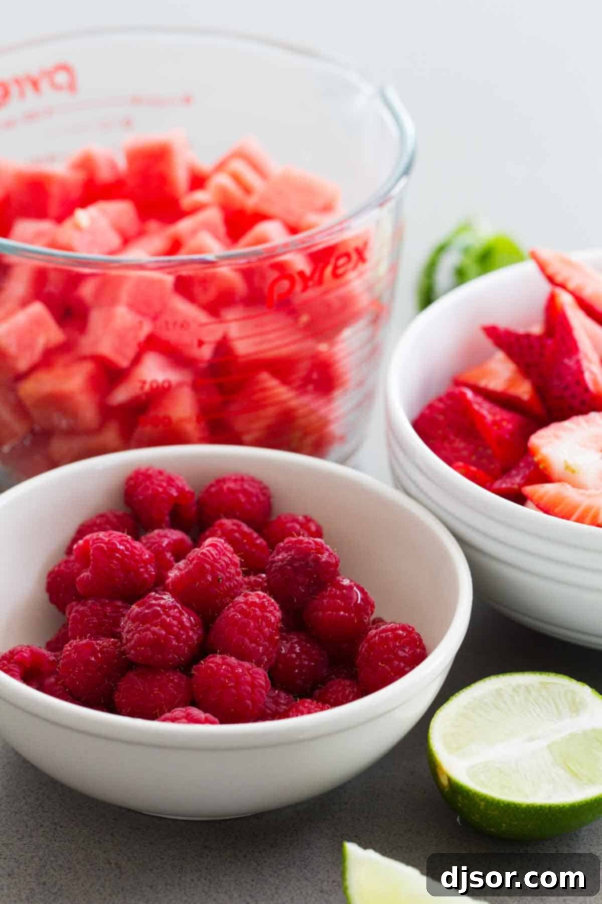 Fresh Ingredients for Crown Ruby Fruit Salad - Watermelon, Strawberries, Raspberries A close-up shot of fresh, colorful berries and ripe watermelon, arranged as ingredients for the Crown Ruby Fruit Salad, highlighting the vibrant reds and greens.