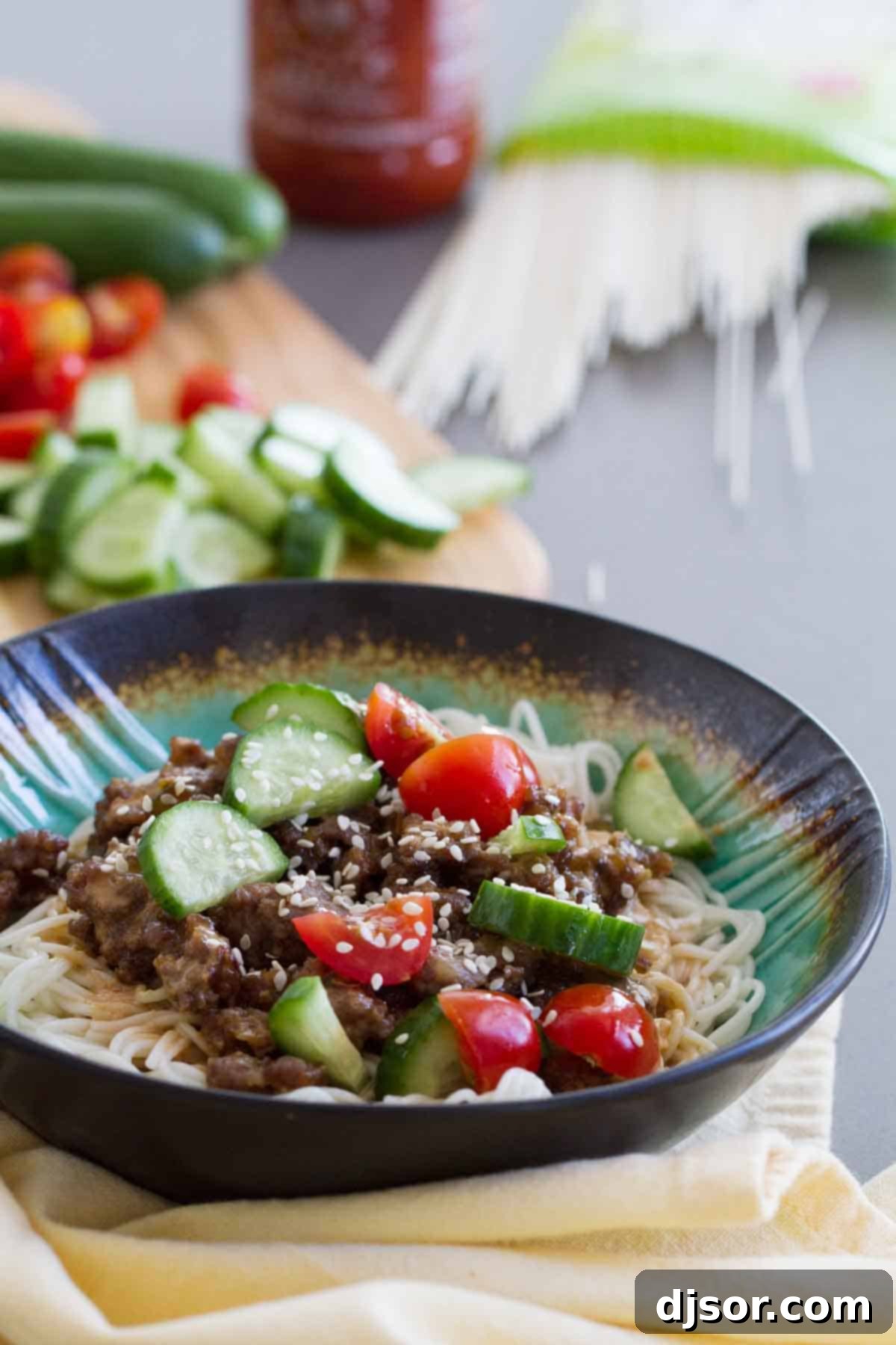 A vibrant Spicy Pork Noodle Bowl with seasoned ground pork, Chinese noodles, and fresh toppings.