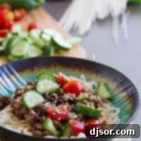 Spicy Pork Noodle Bowl with spicy pork served over Chinese noodles and topped with fresh vegetables.