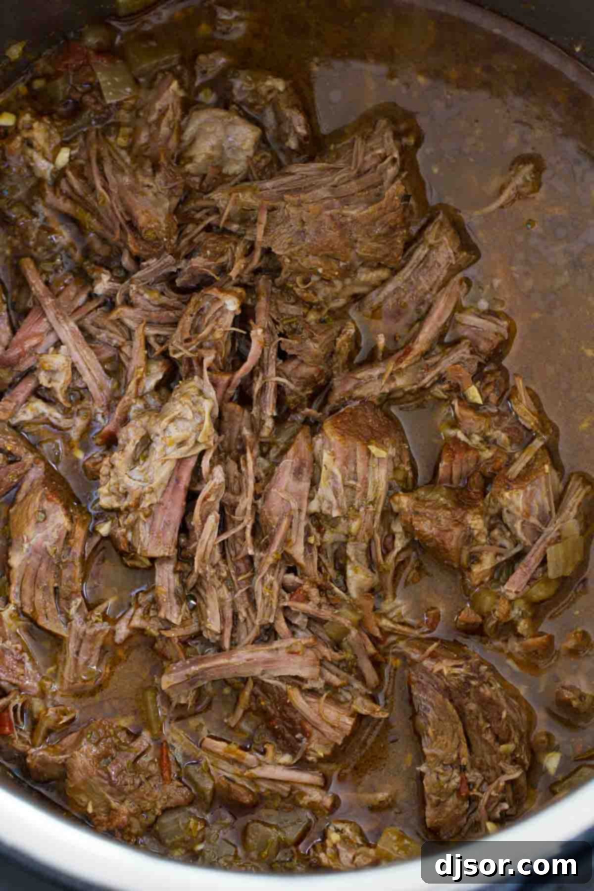 Spice up dinner in a fraction of the time with this Beef Barbacoa in the Instant Pot! Chipotle and cumin make this perfect for tacos, burritos, enchiladas and more! Instant Pot filled with chunks of beef barbacoa simmering in a rich, spiced broth before pressure cooking.