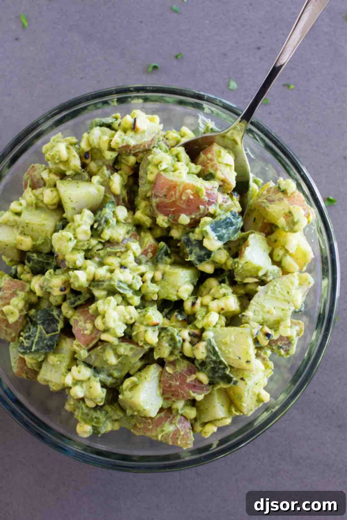 Potato salad with a Tex-Mex twist - this Potato Salad Recipe with Corn and Poblanos combines charred chiles and corn with potatoes and an avocado-cilantro dressing that’s irresistible. bowl full of Potato Salad with Corn and Poblanos