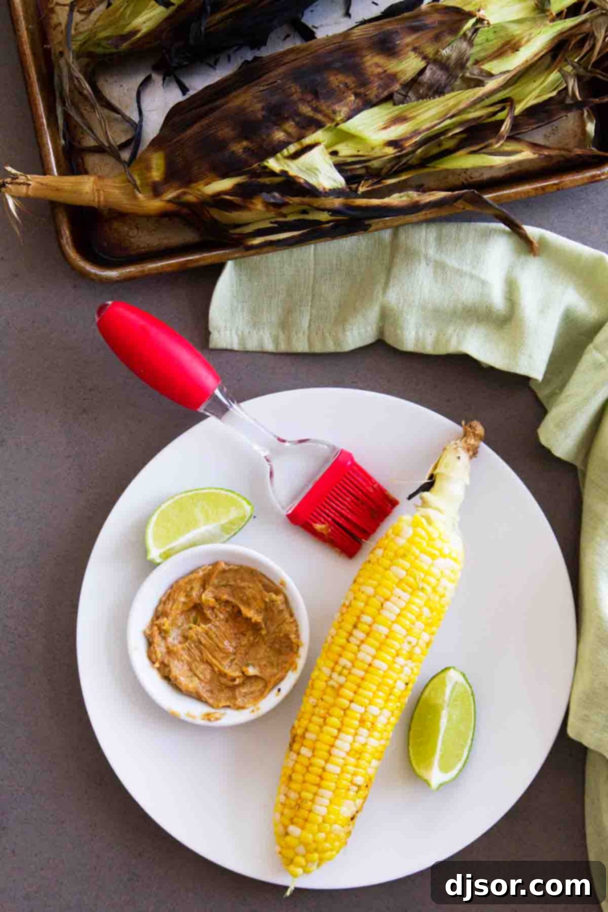 Nothing says summer like grilled corn on the cob! And this Grilled Corn on the Cob with Smoky Butter is so flavorful and the perfect summer side dish. grilled corn on a plate with dish of smoky butter