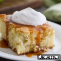 A slice of Apple Cinnamon Cake with caramel and whipped cream on a plate, ready to be served, showcasing its delicious layers and toppings.