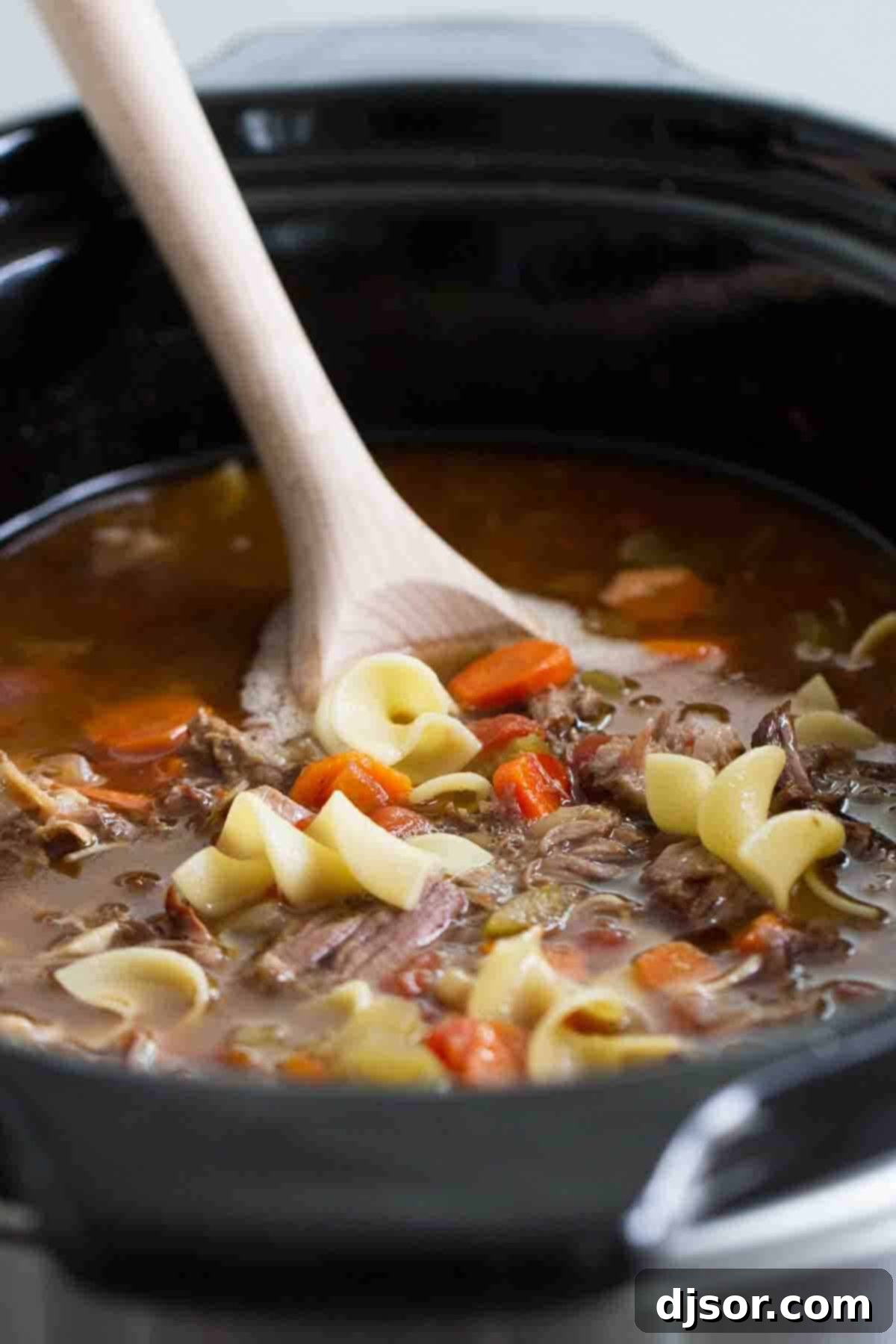 Hearty Beef Noodle Soup: A Slow Cooker Masterpiece Slow Cooker Beef Noodle Soup simmering to perfection in a crock pot, promising warmth and rich flavors.