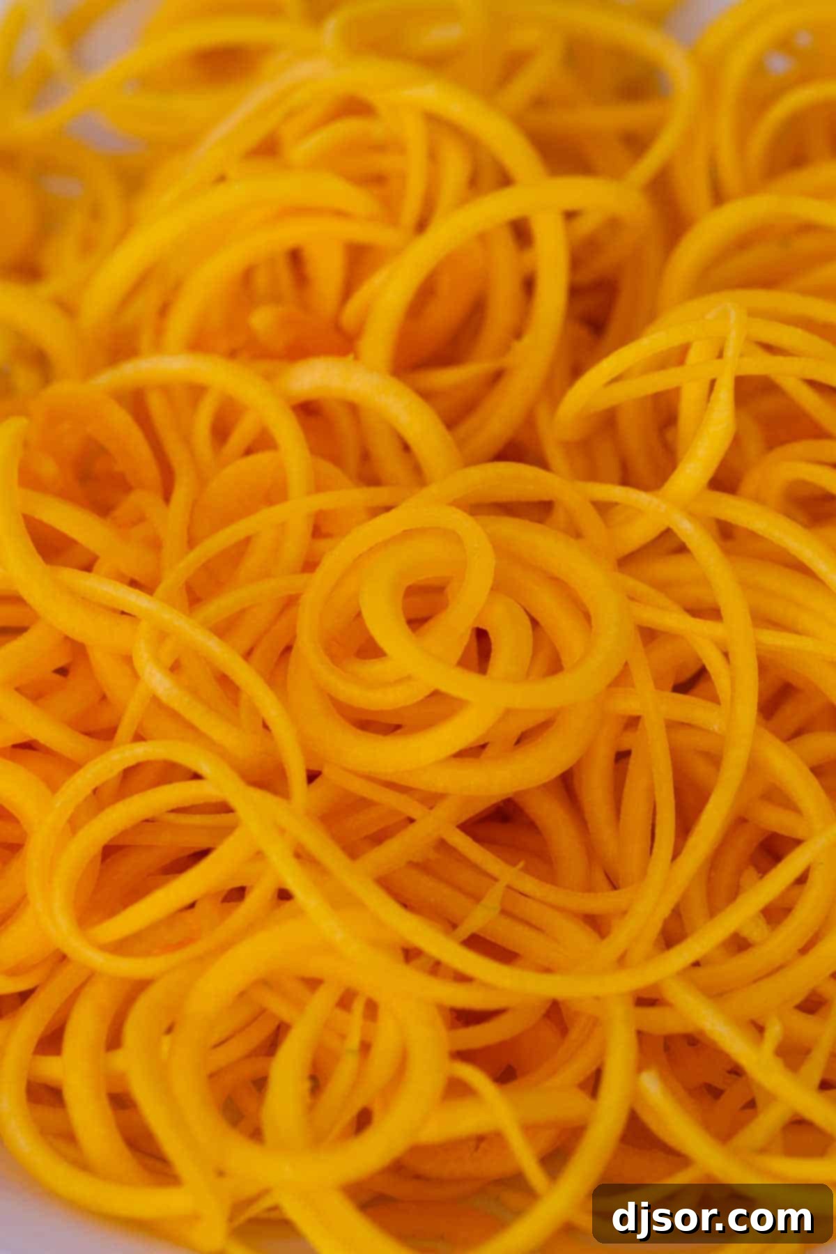 Spiralized Butternut Squash & Bacon Pizza 3 A vibrant pile of freshly spiralized butternut squash, ready for the pizza.