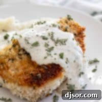 Breaded Pork Chops with herbed gravy, a delicious and comforting meal.