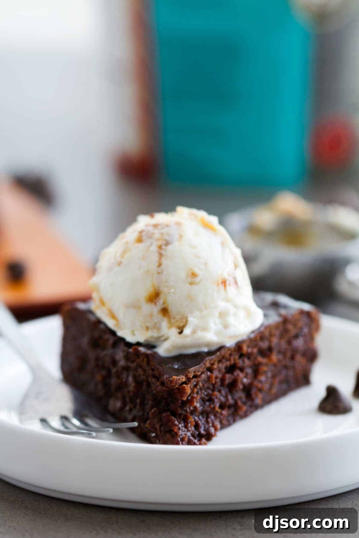A square of pressure cooker fudgy brownie, beautifully topped with a generous scoop of creamy vanilla ice cream.