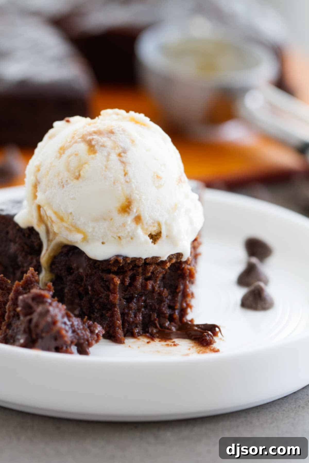 A pressure cooker fudgy brownie with a bite taken out, revealing its rich, gooey texture, topped with melting ice cream.