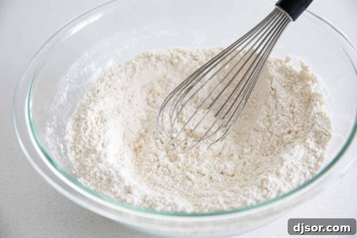 Preparing and Storing Your Homemade Pancake Mix Homemade pancake mix in a large mixing bowl with a whisk, ready for storage