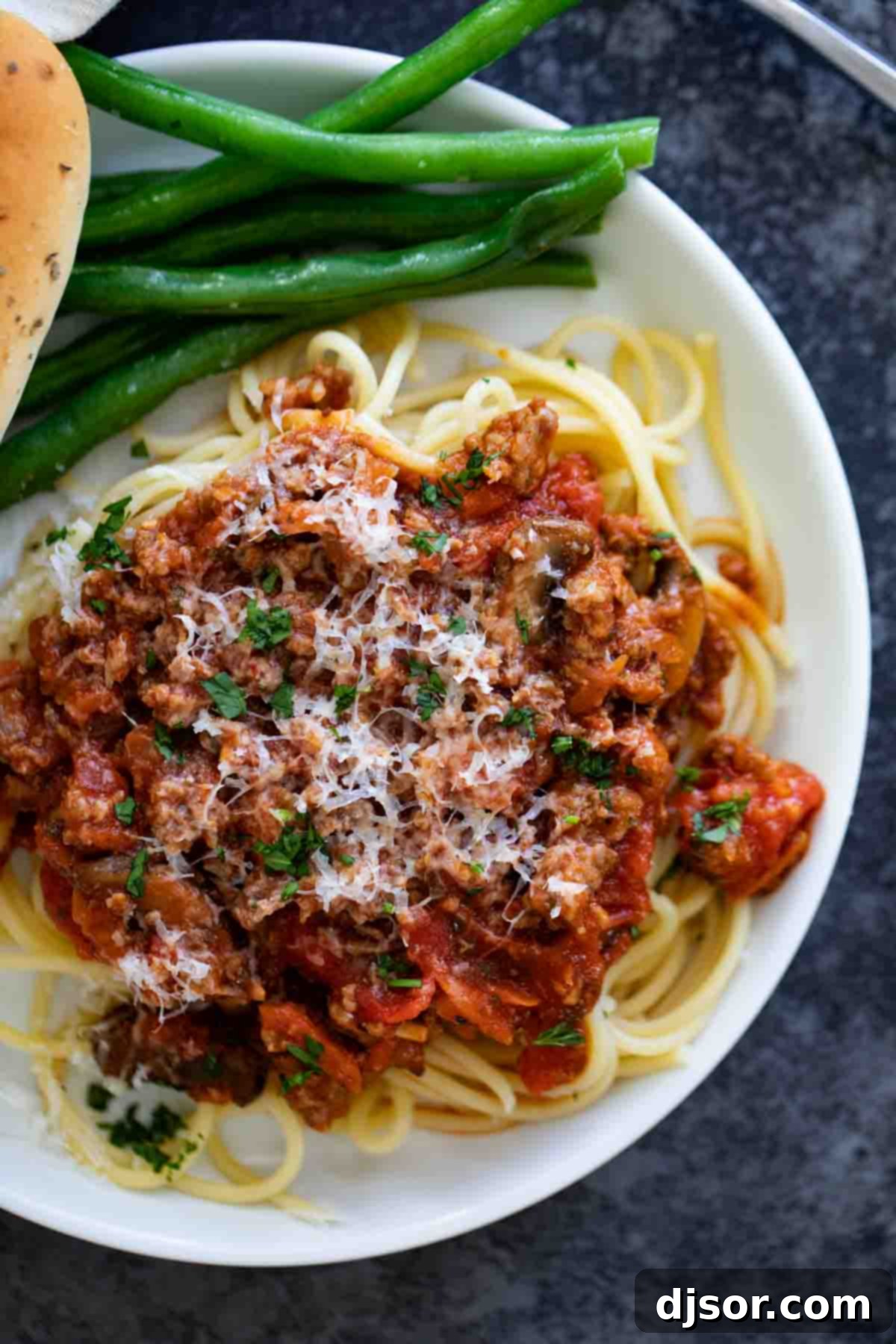 My Signature Spaghetti Sauce 4 Close-up of freshly cooked spaghetti topped generously with homemade meat spaghetti sauce and garnished with parsley.