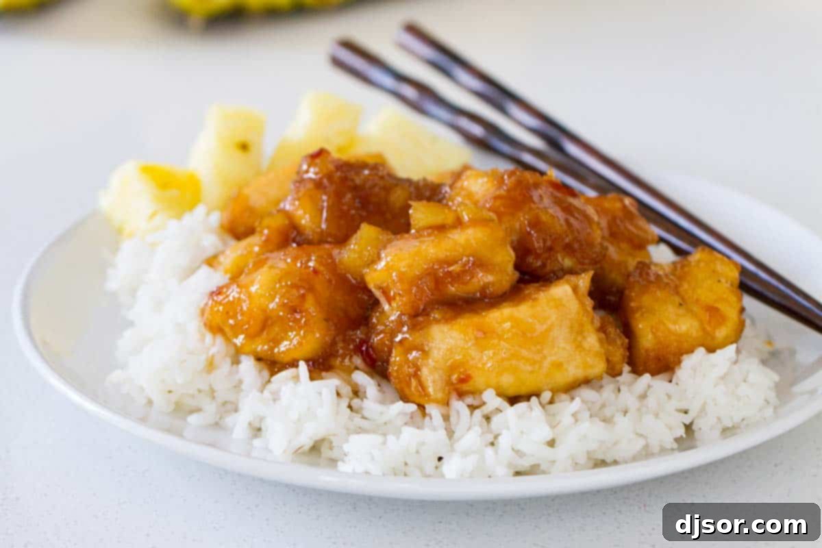 Make it a Make-Your-Own-Take-Out night with this sweet and savory Pineapple Chicken. Crispy chicken is cooked in a sweet pineapple sauce. Serve over rice for a dinner that is sure to be a hit! Pineapple Chicken with chopsticks and rice