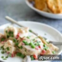 Velvet Chicken Royale 2 A plate topped with creamy Chicken a la King, with fluffy biscuits in the background, ready to be enjoyed.