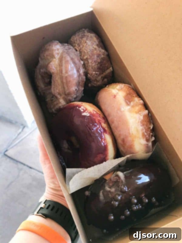 A Box Full of Delight: Sidecar Doughnuts Assortment A neatly packed box of assorted gourmet doughnuts from Sidecar Doughnuts, ready to be enjoyed.