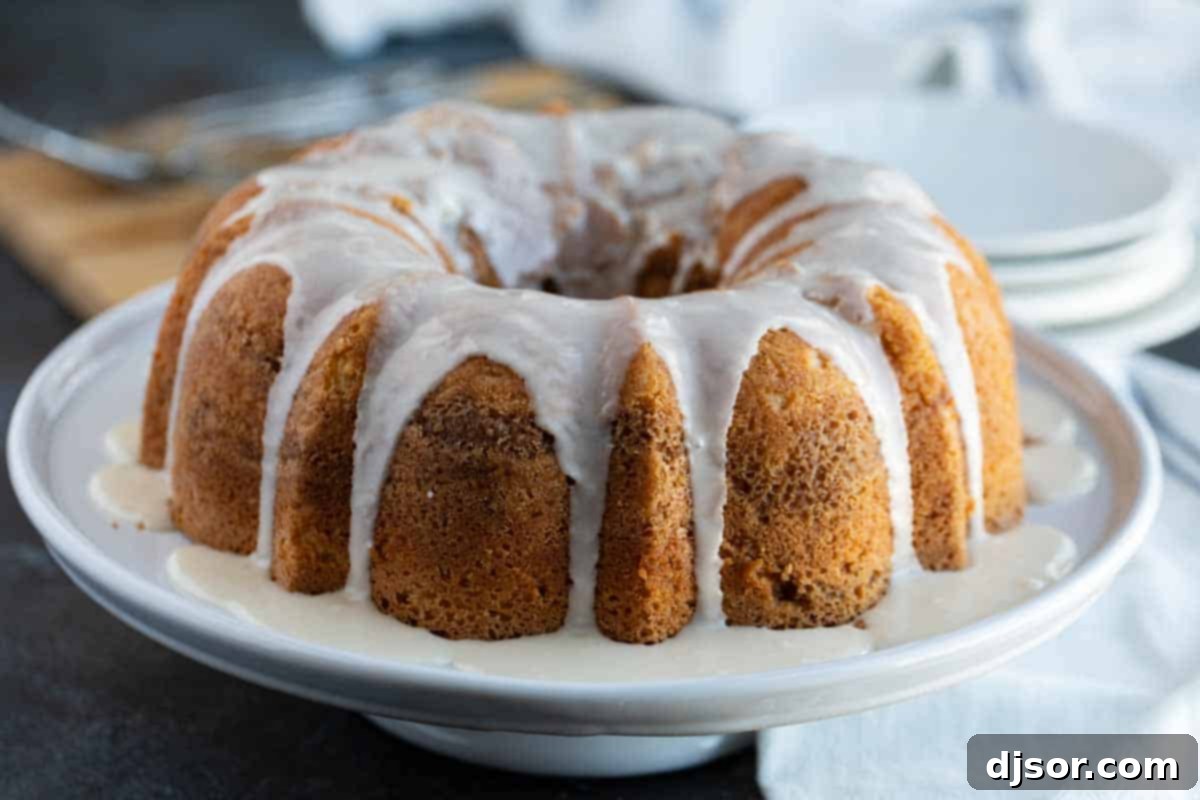 Classic Sour Cream Coffee Cake 2 Sour Cream Coffee Cake with glaze on a cake platter, ready to be served
