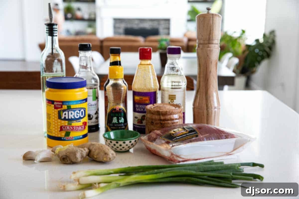 Ingredients laid out for Mongolian beef, including soy sauce, oyster sauce, hoisin, mirin, sugar, sesame oil, cornstarch, flank steak, vegetable oil, garlic, ginger, green onions, and brown sugar.