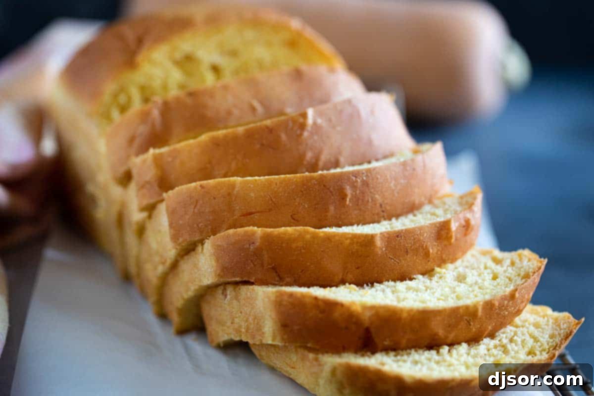 A freshly baked loaf of sliced Butternut Squash Bread, revealing its tender, light orange crumb.