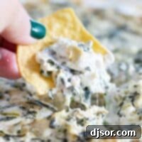 Creamy spinach artichoke dip on a chip, ready to be served