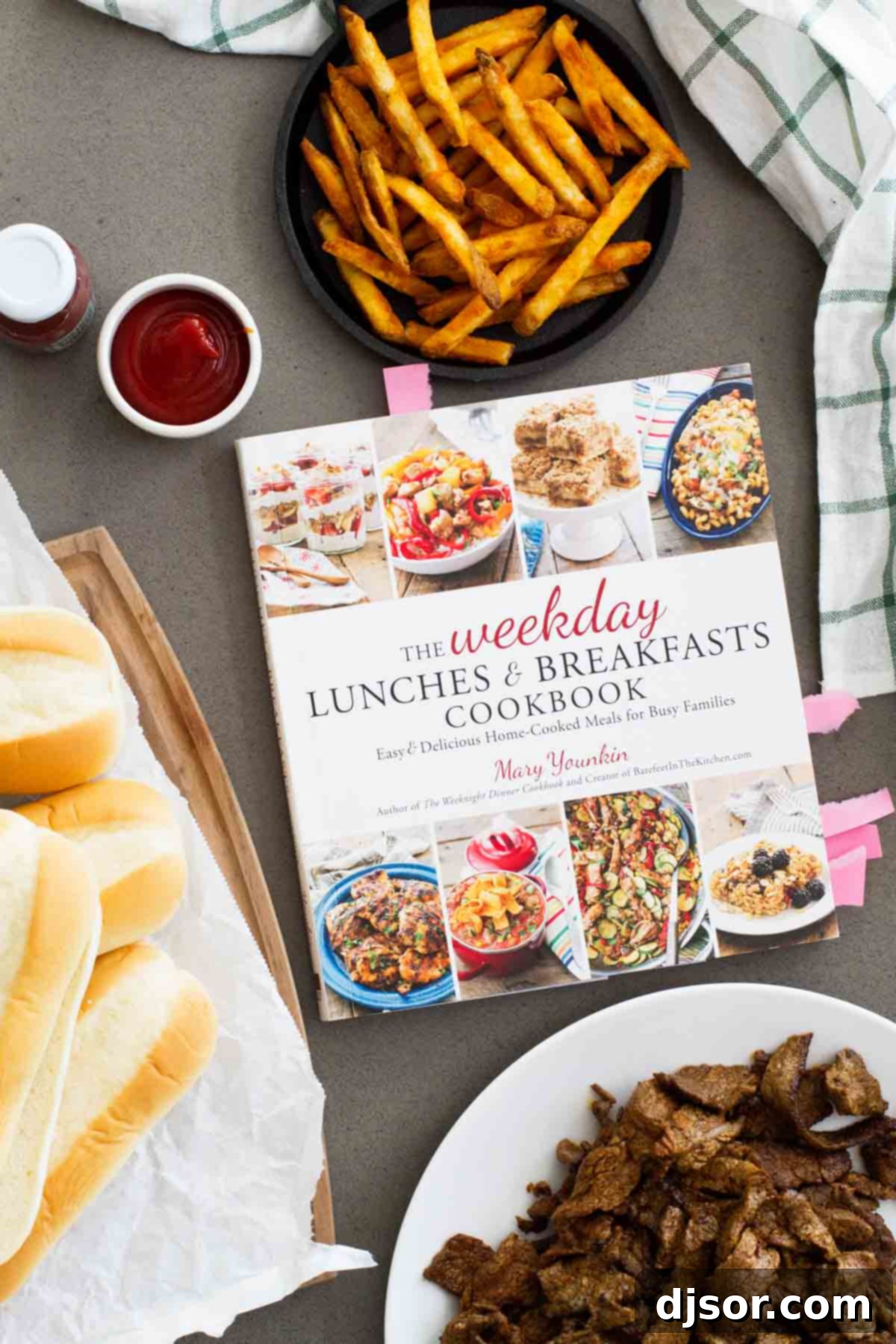 The Weekday Lunches & Breakfasts Cookbook artfully displayed with various fresh ingredients, hinting at the delightful recipes within.