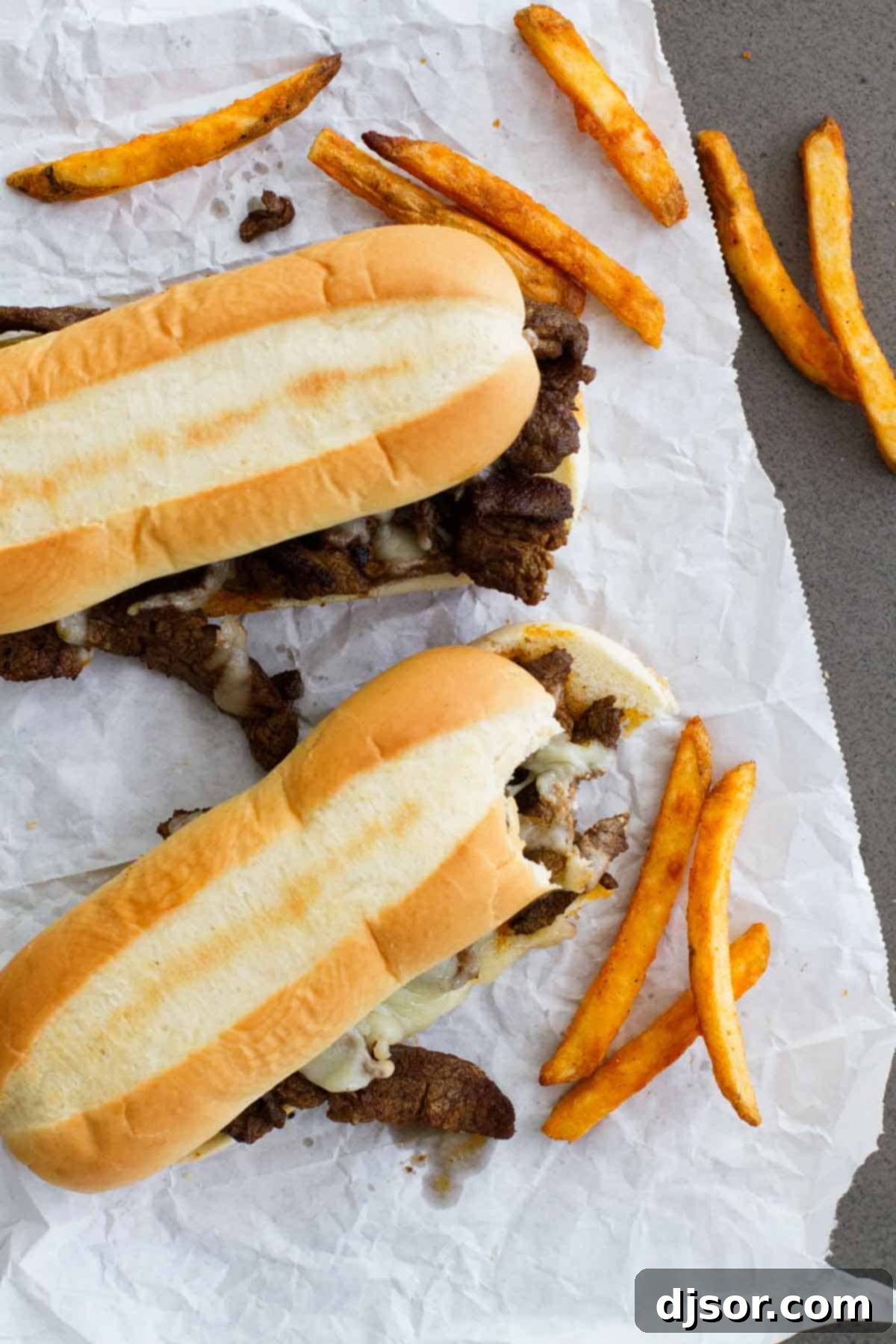 A Spicy Cajun Cheesesteak Sandwich with a bite taken, revealing the melted cheese and flavorful steak inside.