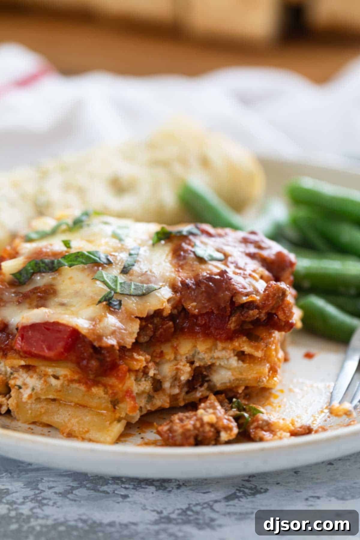Slice of lasagna with a bite taken from it.