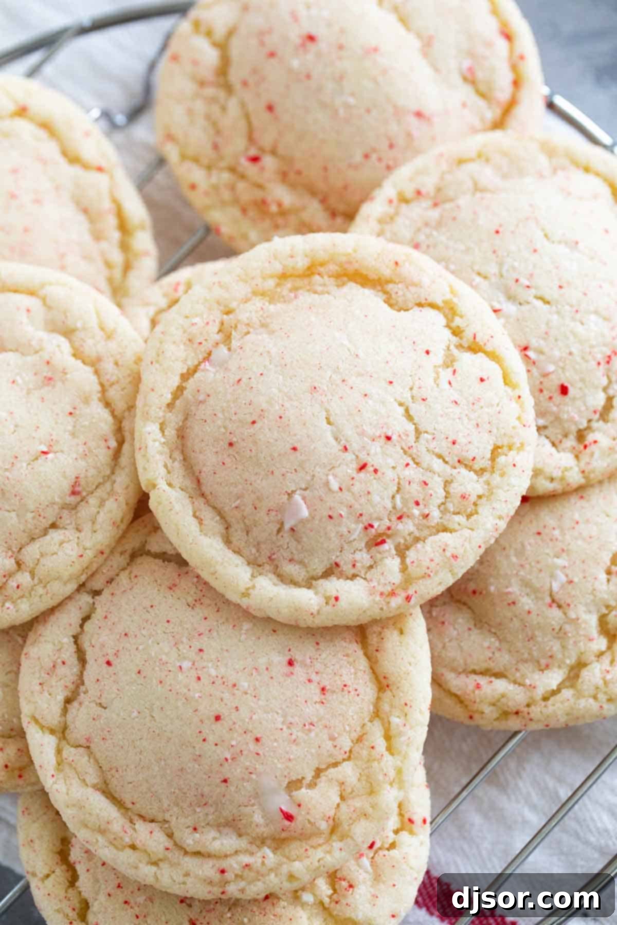 Festive Peppermint Snickerdoodles 7 Freshly baked Peppermint Snickerdoodles stacked neatly on a cooling rack, steam gently rising.