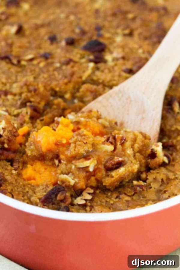 Crafting Your Perfect Thanksgiving 4 A close-up shot of a rich Sweet Potato Casserole with a generous, golden-brown pecan streusel topping, served in a white baking dish.