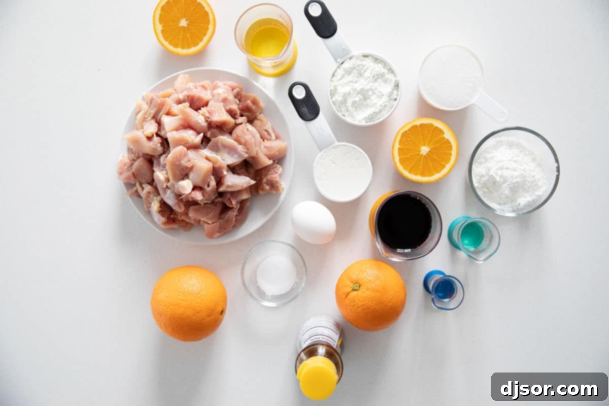 Golden Orange Chicken 2 A selection of fresh ingredients neatly arranged on a counter, ready for making orange chicken, including chicken, oranges, and various sauces.