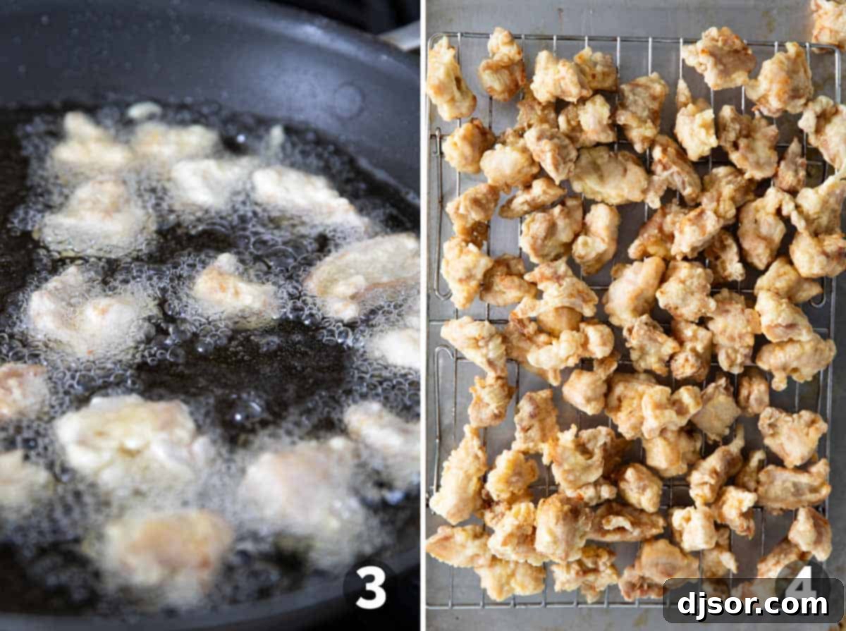 Golden-brown, crispy chicken pieces sizzling in hot oil in a cast iron skillet during the frying process for homemade orange chicken.