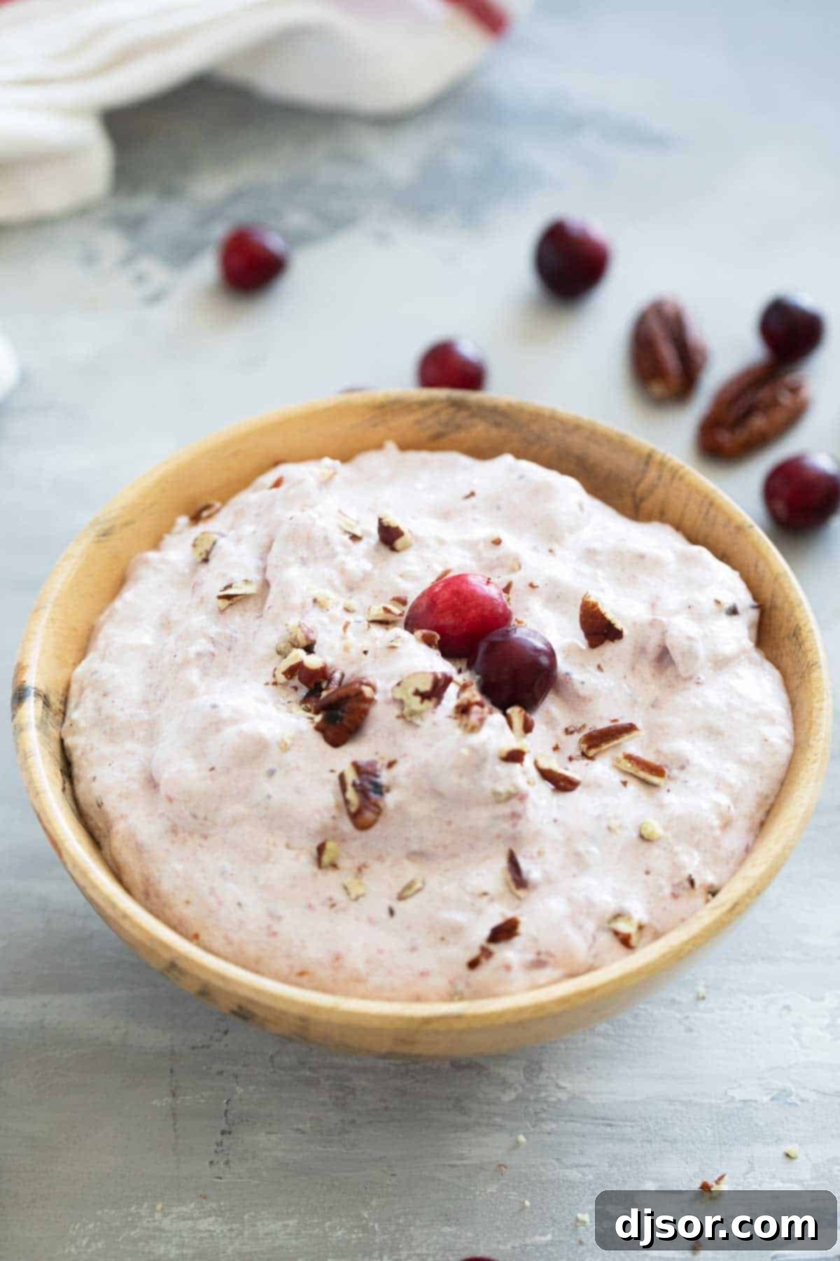 Ruby Red Cranberry Ambrosia 7 A close-up shot of the creamy and festive Cranberry Salad in a rustic wooden bowl, highlighting its vibrant color and delightful texture, ready for serving.