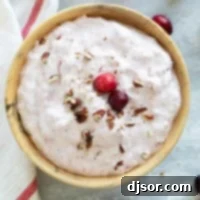 Ruby Red Cranberry Ambrosia 8 Cranberry Salad in a wooden bowl, topped with cranberries and chopped pecans.