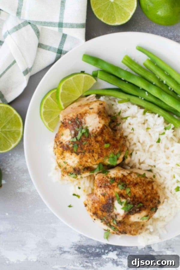 A serving of Easy Lime Baked Chicken Thighs on a plate, garnished with fresh herbs.