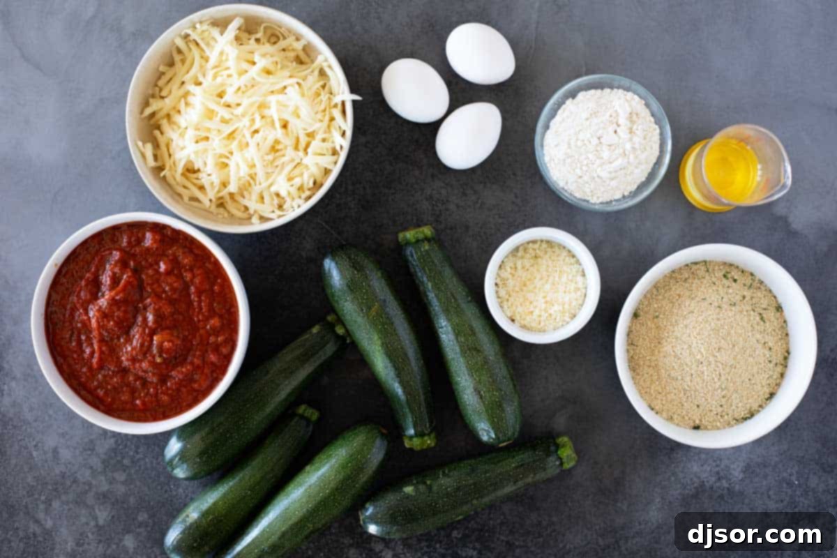 Baked Zucchini Parmesan 3 All the fresh ingredients laid out on a wooden cutting board, ready to be prepared for Zucchini Parmesan, including whole zucchini, eggs, flour, breadcrumbs, marinara, and cheeses.