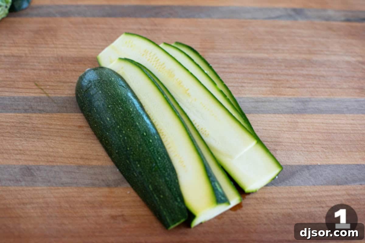Baked Zucchini Parmesan 4 Hands carefully slicing a fresh green zucchini lengthwise into thin, uniform pieces using a sharp kitchen knife on a wooden cutting board.