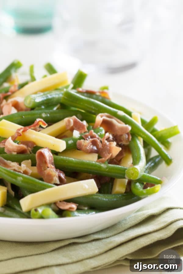 Fresh green beans tossed with crispy frizzled prosciutto and creamy Gouda cheese, served as an elegant side dish.