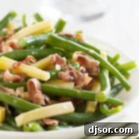 Fresh green beans tossed with crispy frizzled prosciutto and creamy Gouda cheese, served as an elegant side dish.