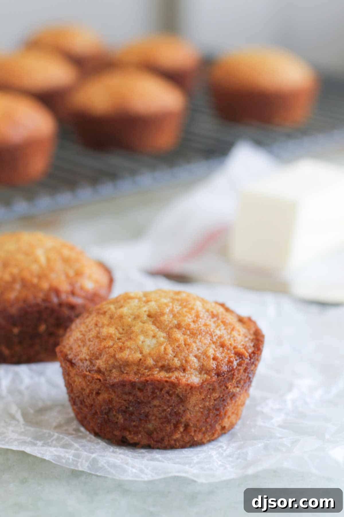 Freshly Baked Brown Sugar Muffins Cooling A batch of golden-brown Brown Sugar Muffins cooling on parchment paper after baking, highlighting their perfect dome tops.