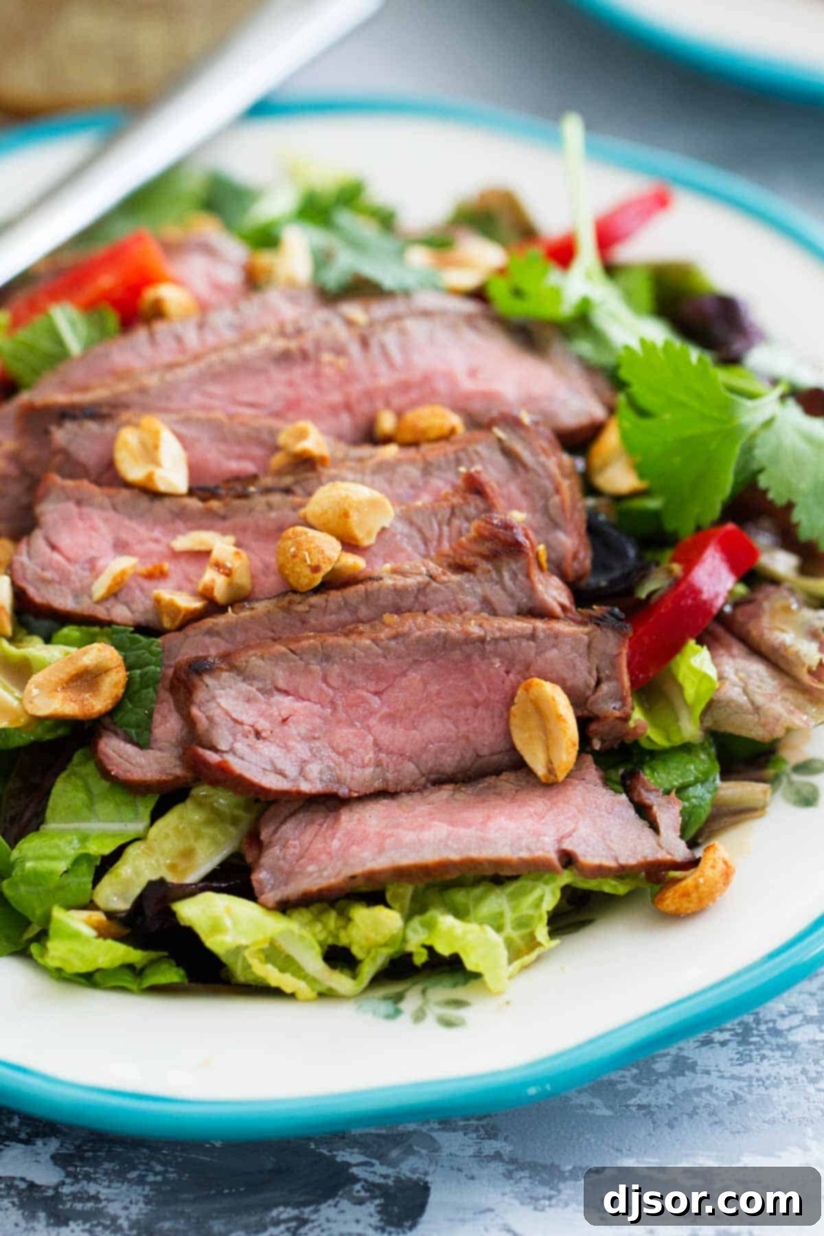 Thai Beef Salad: A Delightful Plate A single serving of Thai Beef Salad beautifully presented on a plate, ready to be enjoyed.
