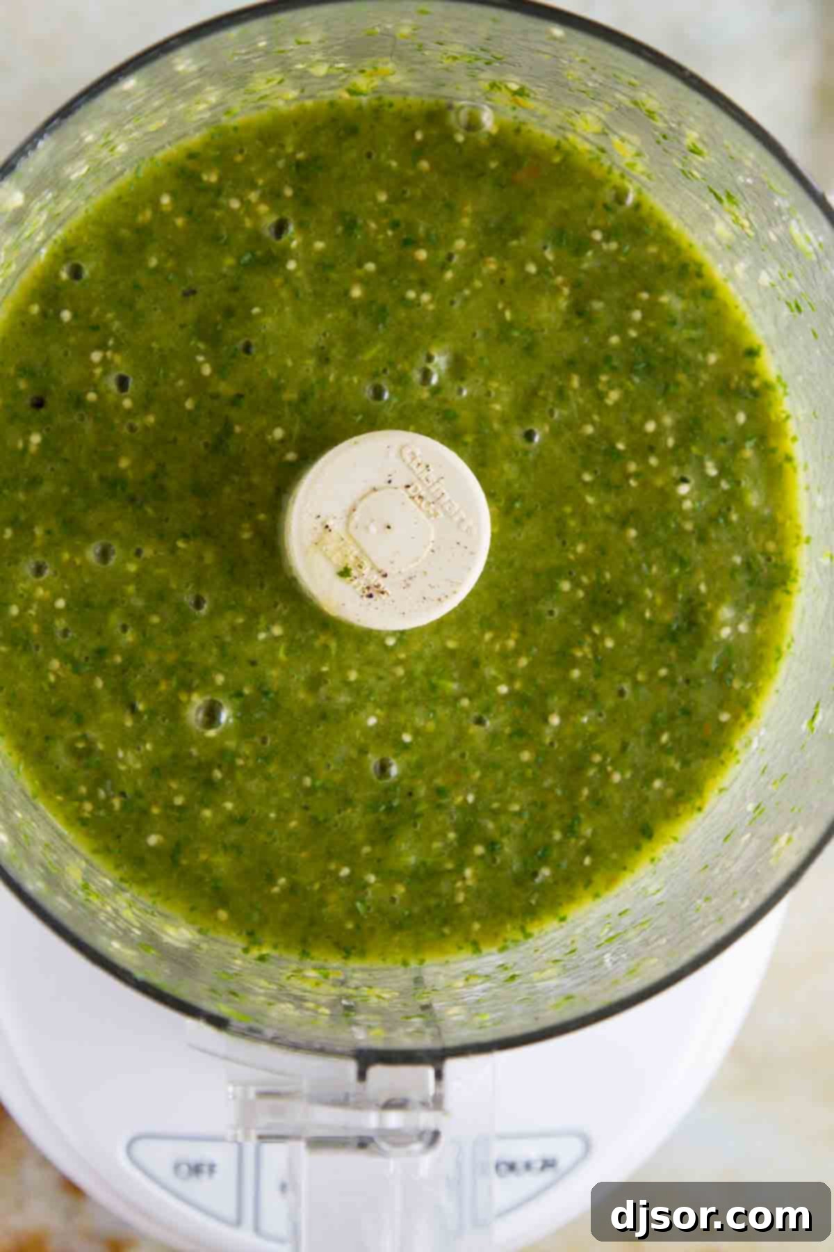 Freshly Blended Tomatillo Salsa Verde Close-up of freshly blended Tomatillo Salsa Verde in a food processor, showing its smooth texture and rich green color.